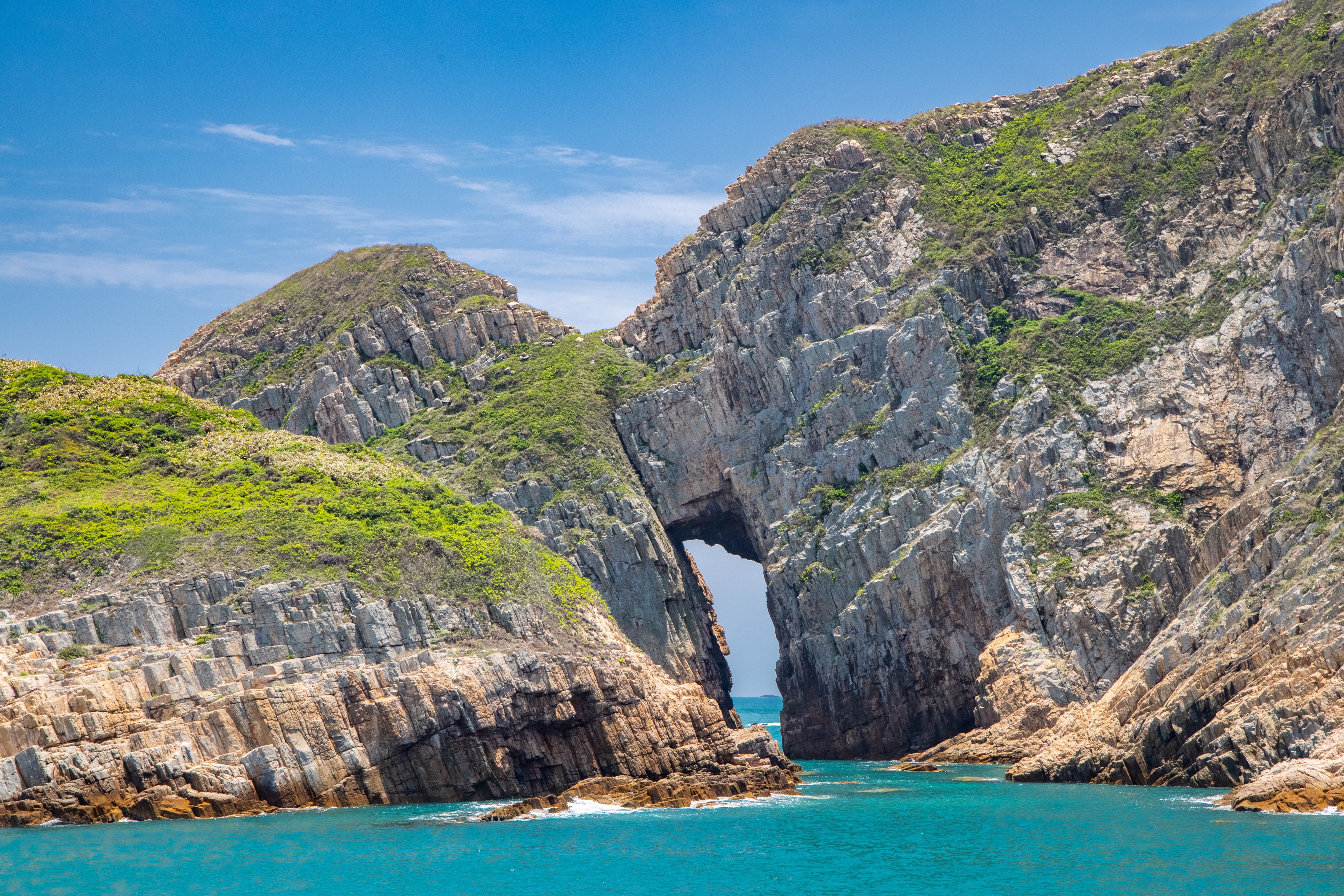 The Agriculture, Fisheries and Conservation Department announced today (October 22) that the Early Cretaceous rhyolitic columnar rock formation located in Hong Kong UNESCO Global Geopark had been selected as one of the First 100 International Union of Geological Sciences Geological Heritage Sites. Photo shows the Early Cretaceous rhyolitic columnar rock formation and a sea arch visible on Basalt Island.